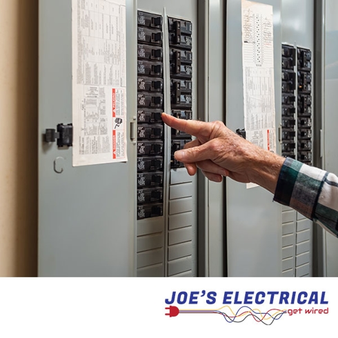 An electrical fuse box, with someone flipping one of the fuses.